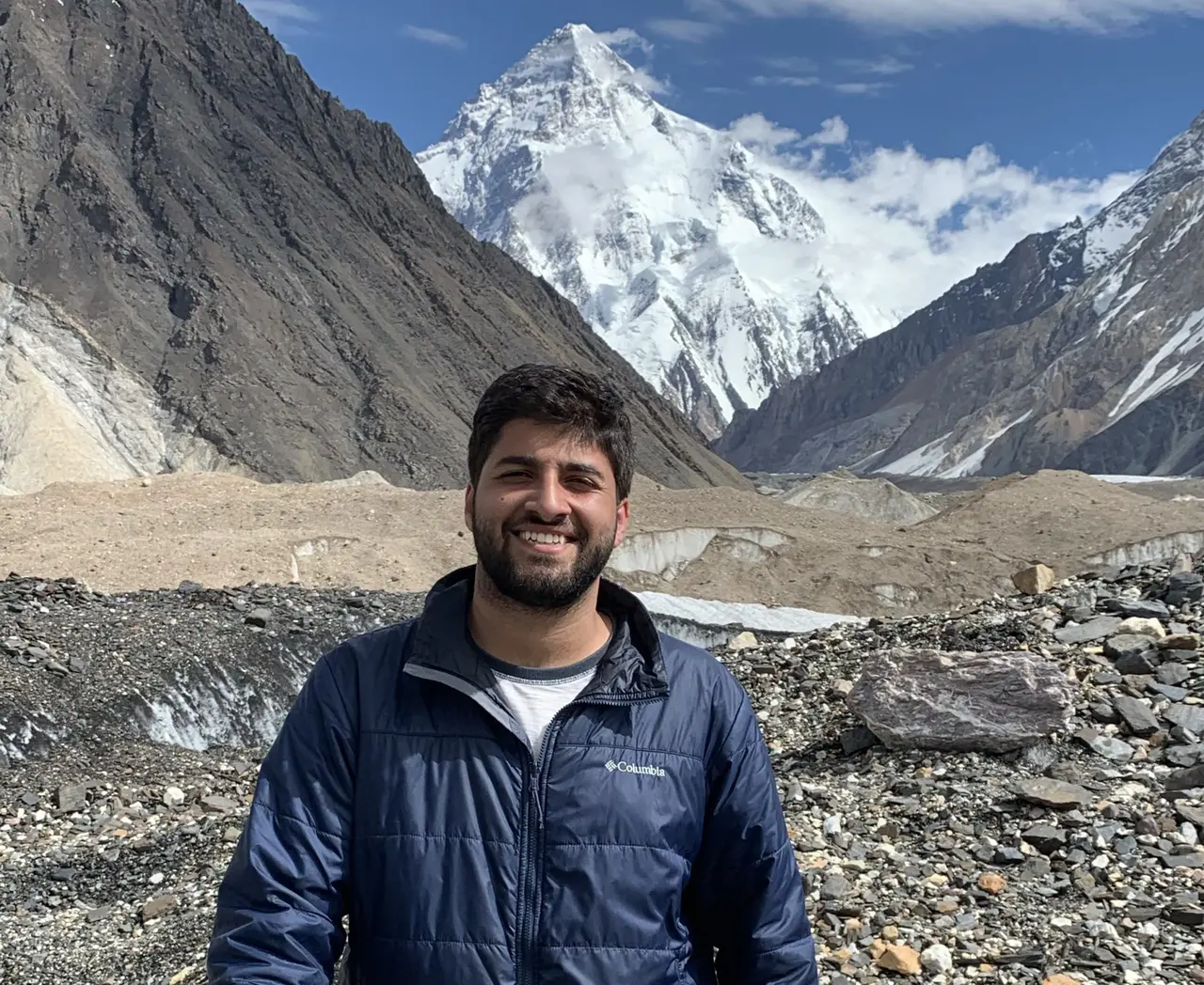 Emaad Paracha on the Baltoro Glacier with K2 behind him
