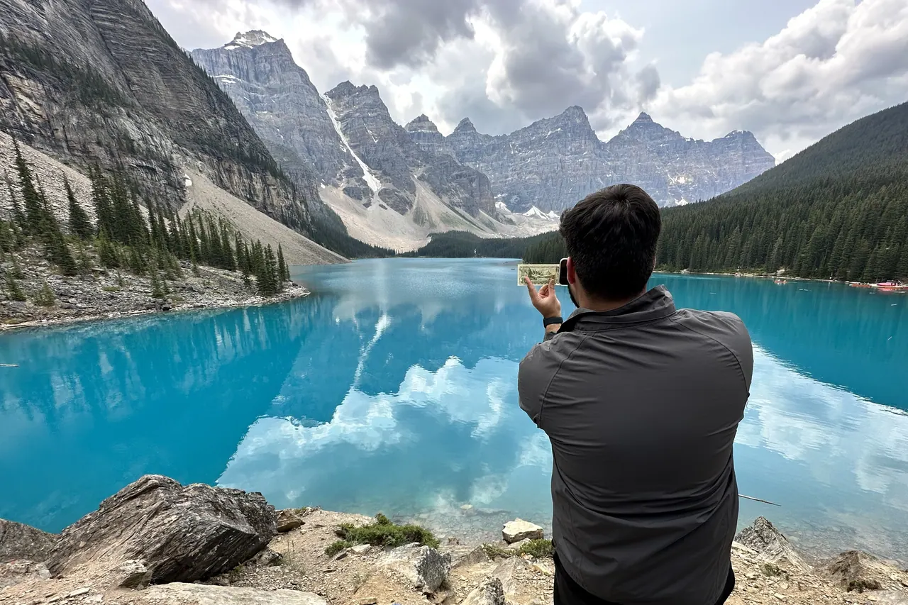 Emaad holding up the old Canadian 20 dollar note at Moraine Lake, Banff